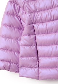 Lila gesteppte Jacke mit horizontalen Nähten, ausgestattet mit einem Reißverschluss an der Unterkante.