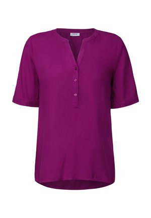 Blusa corta viola a maniche corte con scollatura a V e patta con bottoni. Tessuto liscio, vestibilità rilassata, orlo arrotondato e leggero luccichio. Etichetta del marchio visibile.