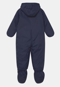 Tuta da neve isolante di colore blu navy con cappuccio, maniche lunghe e piedi attaccati. Materiale liscio e resistente all'acqua con polsini elasticizzati.
