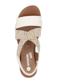 Sandale blanche et marron avec un motif tissé sur les lanières, une semelle intérieure douce et une fermeture latérale réglable. Les contrastes de couleur mettent en valeur le design.