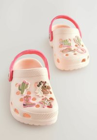 Leichte, rosa und cremefarbene Clogs aus einem leichten Material, ausgestattet mit dekorativen Patches – Kaktus, Pferd, Cowboy-Stiefel und Stern – sowie Belüftungsöffnungen.
