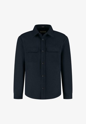 Granatowa koszula zapinana na guziki, wykonana z miękkiego materiału, z kołnierzykiem, dwiema kieszeniami na piersi i długimi rękawami. Guziki w kontrastowym kolorze.