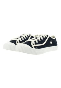 Scarpe da ginnastica in tela blu navy con punte e suole in gomma bianca. Presentano lacci bianchi e dettagli laterali. Suola con grip testurizzato.