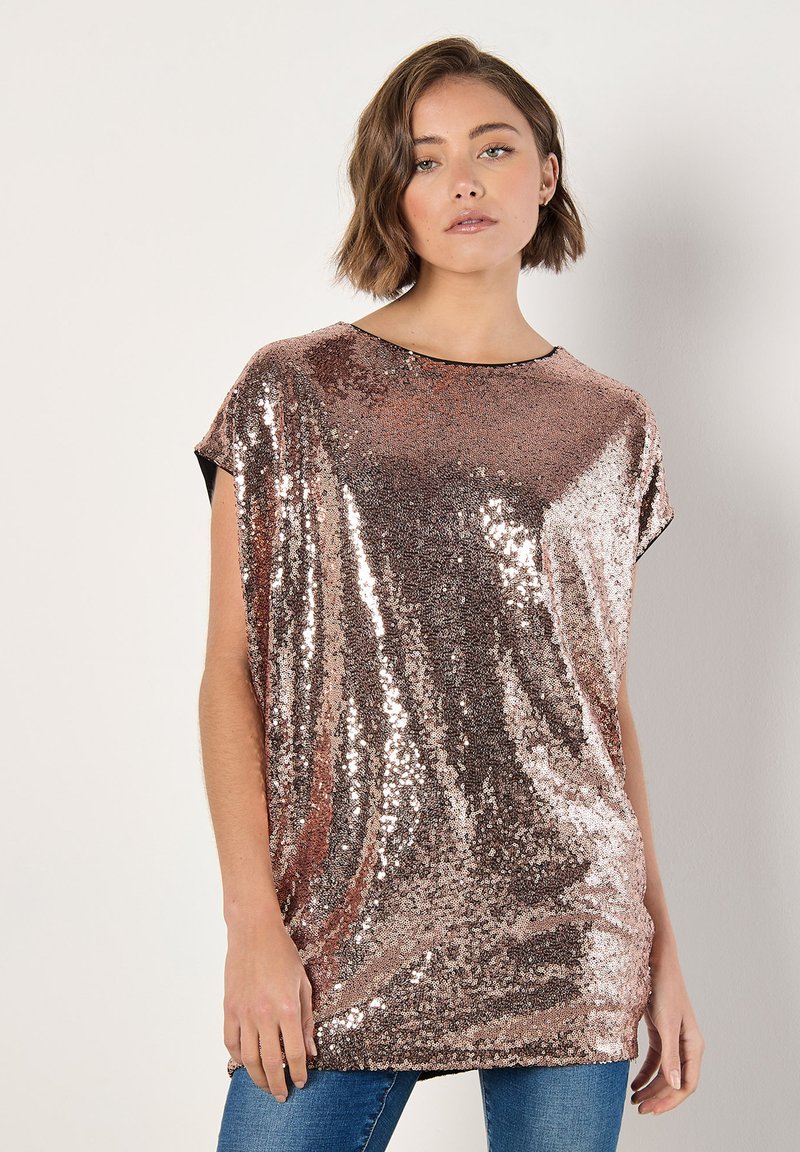 Top de lentejuelas en color dorado rosa con silueta holgada. Presenta mangas cortas, cuello redondo y una textura suave y reflectante.