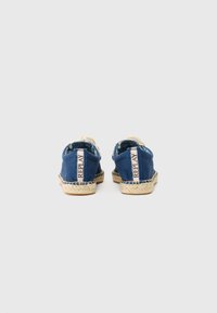 Espadrilles en toile bleue avec une semelle en jute tressé et un onglet de talon contrastant. Dotées d'un logo subtil sur le côté en texte clair.