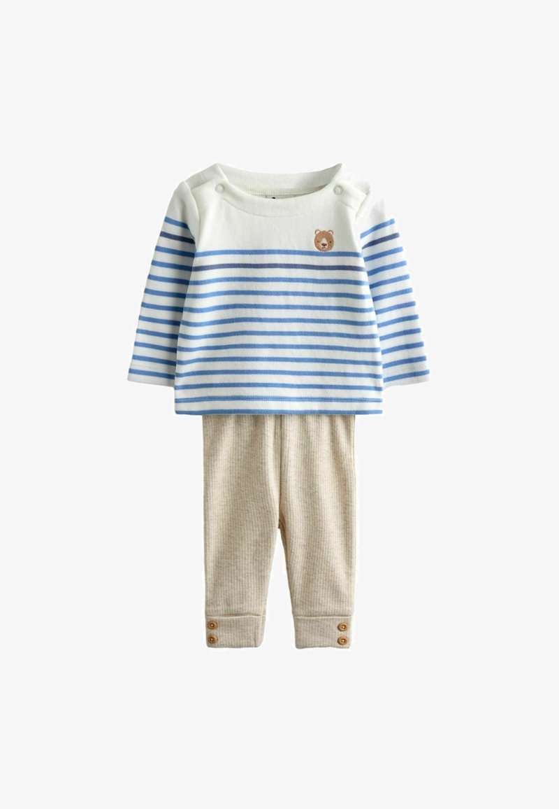 Bebi majica s bijelim i plavim prugama dugih rukava, s malenim likom medvjedića na prsima, u kombinaciji s bež rebrastim hlačama s manžetama na kopčanje.