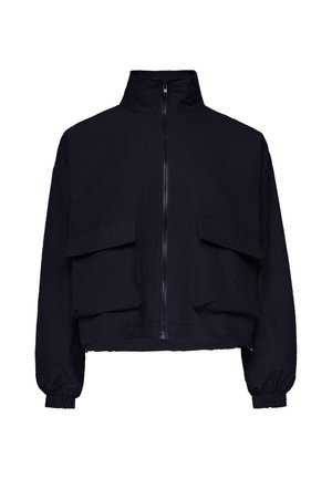 Giacca nera con zip e collo alto, due grandi tasche frontali con pattina, polsini elastici e tessuto con trama texturizzata.