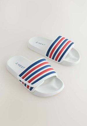 Șlapi albi cu o curea largă având dungi albastre, roșii și albe. Talpă texturată pentru aderență; logo-ul "NEXT" vizibil pe curea.