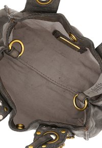 Interno di una borsa a tracolla in pelle grigia con finiture in oro, texture liscia e fodera in tessuto. Include occhietti metallici e un'etichetta.