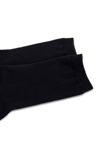 Calze di cotone nere con una texture a coste, caratterizzate da un bordo liscio e una punta senza cuciture, che mostrano un design semplice e un colore uniforme.