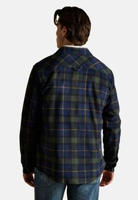 Button-up-Hemd aus karierter Flanellstoffe in Marineblau und Grün, mit klassischem Kragen, langen Ärmeln und abgerundetem Saum. Strukturierte Stoffqualität mit gelben Akzenten.