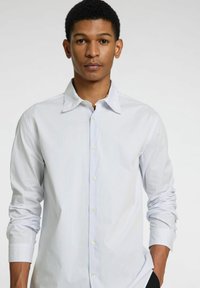 Camisa de botones en azul claro con rayas blancas, con cuello puntiagudo, mangas largas y una suave tela de mezcla de algodón.