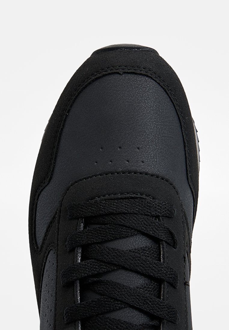 Czarne trampki z gładką skórzaną cholewką, zamszowymi akcentami, okrągłym noskiem, płaskimi sznurowadłami oraz perforowanymi detalami na nosku.