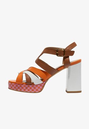 Sandale à talon haut à brides marron, orange et blanc avec un talon blanc épais et une semelle plateforme à carreaux rose.