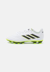 Botas de fútbol blancas con diseño texturizado, detalles en negro y verde neón, cierre de cordones y tacos moldeados para tracción en superficies de hierba.