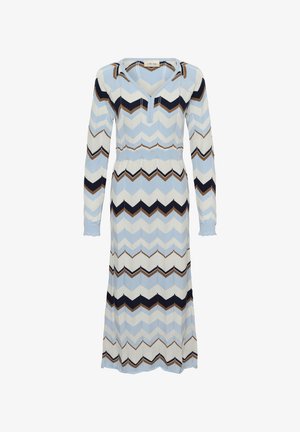 Pitkä neulemekko, jossa on chevron-kuvio vaaleansinisessä, tummansinisessä ja ruskeassa. V-pääntie ja pitkät hihat, joissa on frillakujat.