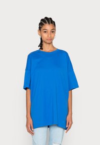 Blauwe oversized t-shirt gemaakt van zachte katoen. Beschikt over een ronde hals en korte mouwen, met een ontspannen pasvorm en zijsplitten aan de onderkant.