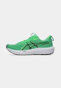 Zapatillas deportivas verdes con una parte superior texturizada, con acentos negros y una entresuela blanca, diseñadas para ofrecer comodidad y soporte en la carrera.