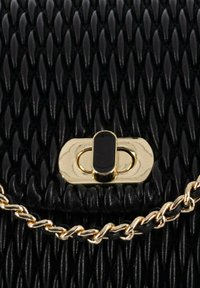 Borsa intrecciata nera con superficie testurizzata. Presenta una chiusura e una tracolla a catena color oro, che mettono in risalto un design elegante e moderno.