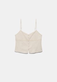 Camisole sans manches de couleur crème avec fines bretelles réglables, fermeture à boutons sur le devant et bordure en dentelle le long du bord supérieur.