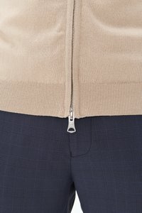 Gaišais sarkanpelēkais džemperis ar rāvējslēdzēju un ribotām malām, kombinēts ar jūras zilā krāsā šūtu biksēm, kas satur delikātu rūtiņu rakstu. Rāvējslēdzējs ar metāla apdari.