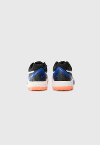 Black athletic shoes with a textured mesh upper, blue accents, and a white midsole. The sole is orange with a zigzag pattern for traction.
