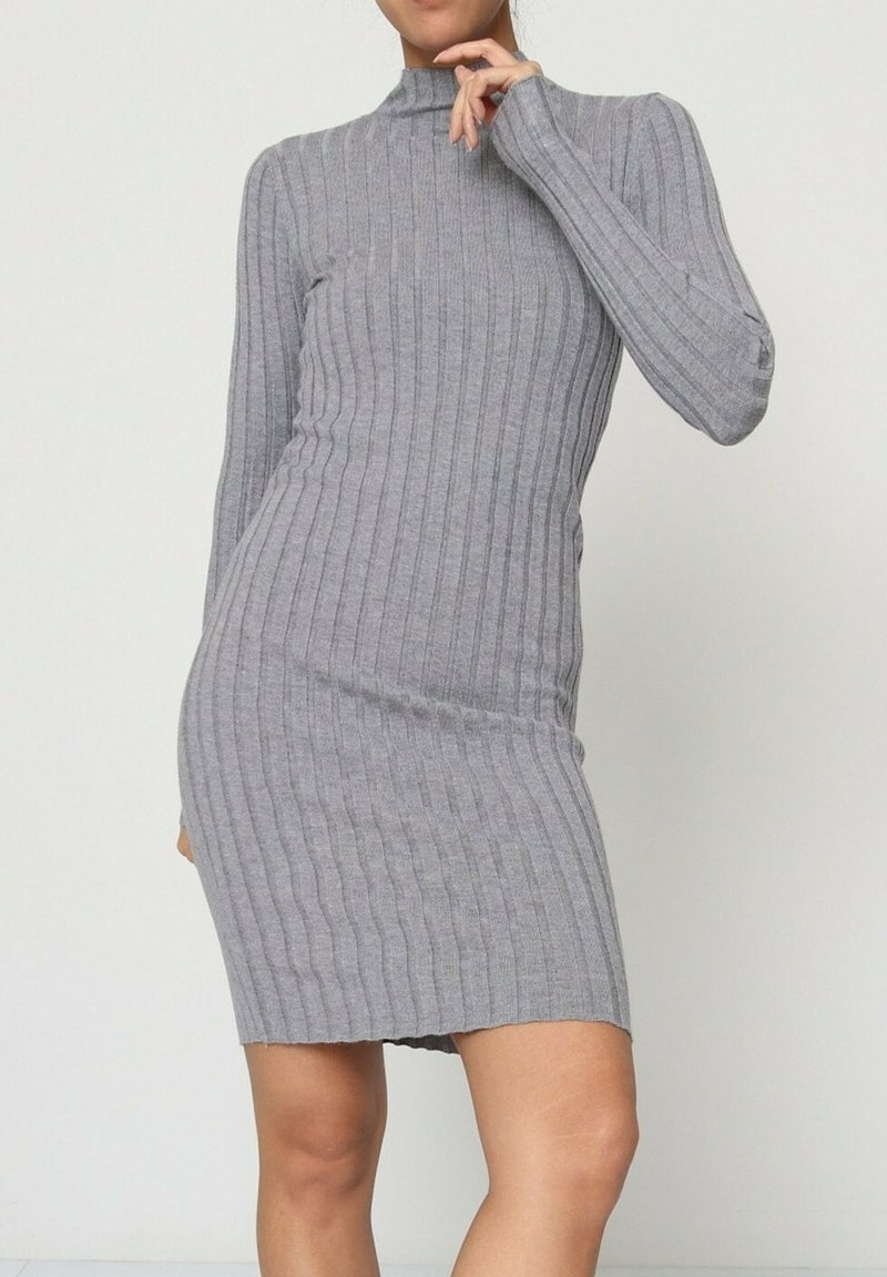 Robe tricotée grise à côtes avec manches longues et col montant. Le tissu a une texture lisse et s'ajuste étroitement au corps, se terminant au-dessus de la mi-cuisse.