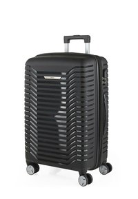 Maleta rígida negra con un acabado mate, diseño acanalado, asa retráctil, cuatro ruedas giratorias y detalles de hardware en plata.