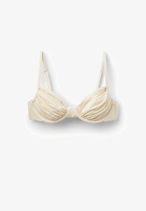 Soutien-gorge en satin couleur crème avec bonnets froncés et bretelles fines réglables sur fond blanc.