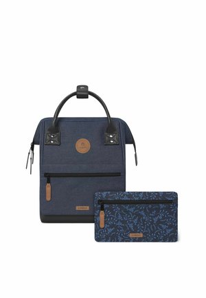 Navy blue backpack with a textured finish, black leather accents, round logo patch, front zip pocket, and detachable navy floral pouch.