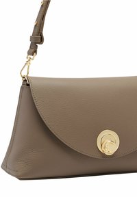 Borsa a tracolla in pelle marrone con chiusura a soffietto, caratterizzata da un accento circolare dorato e una tracolla regolabile. Superficie testurizzata con dettagli di cucitura.