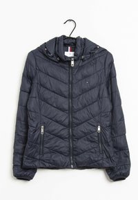 Giacca imbottita blu navy con cappuccio, motivo trapuntato a Chevron, due tasche frontali con cerniera e polsini elasticizzati. Caratterizzata da dettagli in metallo argentato.