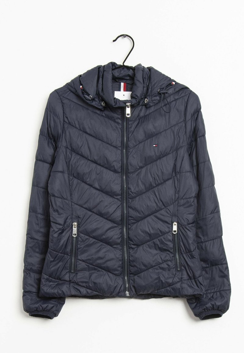 Giacca imbottita blu navy con cappuccio, motivo trapuntato a Chevron, due tasche frontali con cerniera e polsini elasticizzati. Caratterizzata da dettagli in metallo argentato.