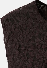 Top in pizzo di un intenso bordeaux con motivi floreali, caratterizzato da una finitura testurizzata e un design senza maniche. Realizzato in materiale leggero e traspirante.