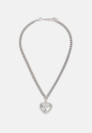 Srebrny naszyjnik z łańcuszkiem, z zawieszką w kształcie serca z ażurowym motywem kwiatu i małymi kryształkami wokół krawędzi.