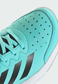 Tyrkysová sportovní bota s texturovaným svrškem, perforacemi pro ventilaci, černými akcenty a tkaničkami v odpovídající barvě.