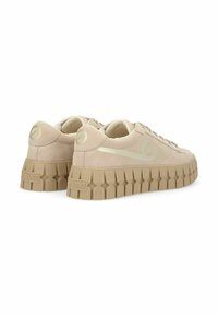 Beige suede sneakers with a thicker tan rubber sole. Features a rounded toe, tonal laces, and a subtle logo on the heel and side.
