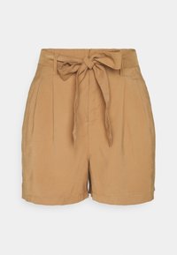 Shorts taille haute couleur sable avec plis, passants pour ceinture, et ceinture en tissu nouée à la taille, sur un fond uni.