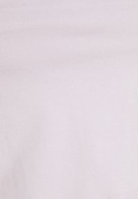 Light pink ribbed fabric with a smooth texture, featuring a subtle sheen and a small hem at the bottom. No visible patterns or graphics.