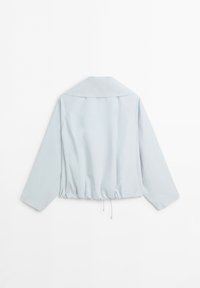 Giacca azzurro chiaro a maniche lunghe con ampio colletto e orlo con coulisse regolabile, mostrata da dietro su sfondo bianco.