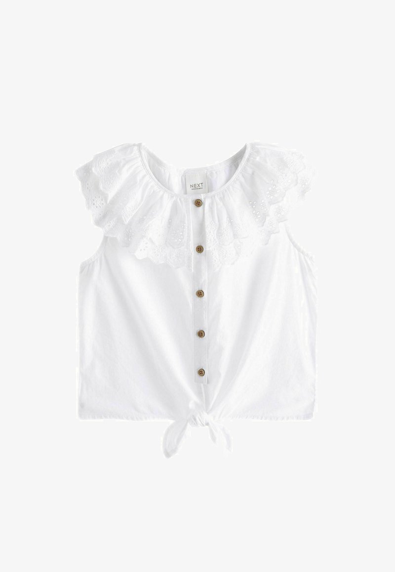 Vitt ärmlös topp med en rynkad broderad krage, träknapp framtill och knytdetalj längst ner. Tillverkad av bomull, lätt material.