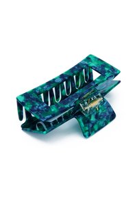 Plastklämma för hår i grön och blå marmorering, med en böjd design och spårade öppningar samt en gyllene metallfjädermekanism.