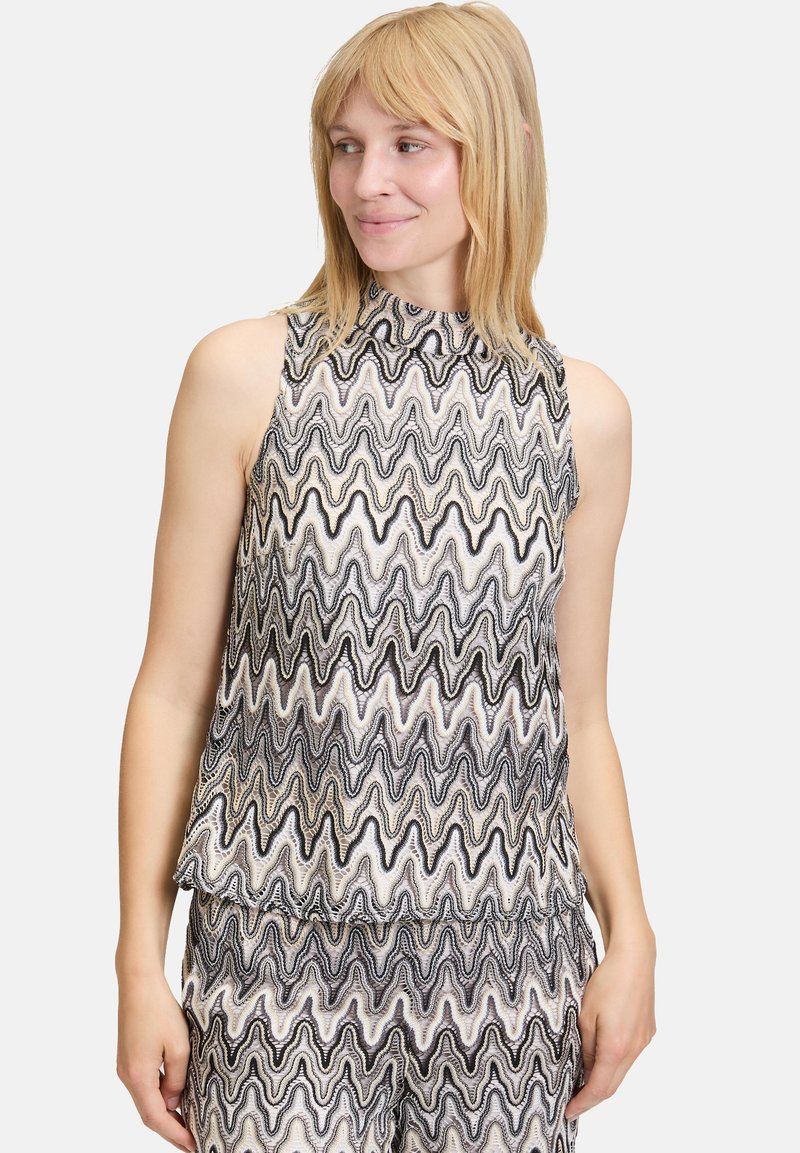Czarny i biały bezrękawnik z wysokim dekoltem, z wzorem fal oraz teksturowaną powierzchnią. Lekka i luźna konstrukcja.