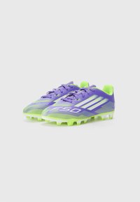 Scarpini da calcio vibranti di colore viola e verde con una tomaia sintetica testurizzata, caratterizzati da un marchio bianco e una suola con tacchetti per una migliore trazione.