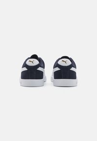 Marineblå ante sneakers med hvite accenter, med en hvit hælflik og gulllogo bak. Tykk hvit gummisåle.