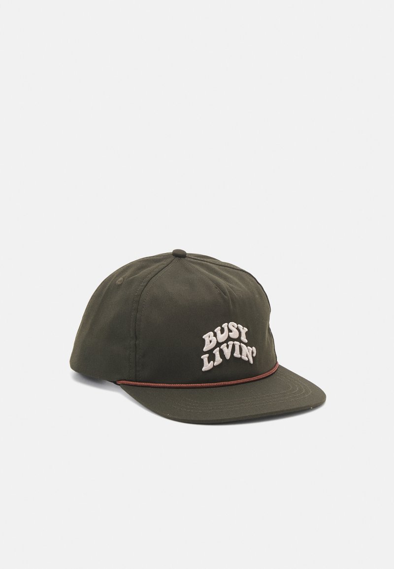 Oliven grønn baseballcaps med buet skjerm, prydet med hvit brodert tekst "BUSY LIVIN'" og en brun aksent langs skjermens kant.