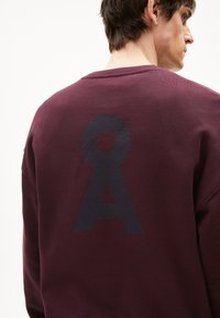 Bordeaux sweatshirt met een textuur van een marineblauwe "A"-grafiek op de achterkant. Heeft een ronde halslijn en een zachte textuur van de stof.