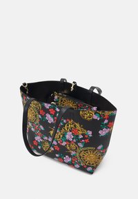 Taška na rameno z černého syntetického materiálu s květinovým potiskem ve fialové a červené barvě, zlatými doplňky a dvojitými koženými popruhy. Uvnitř obsahuje kapsičku se zipem.