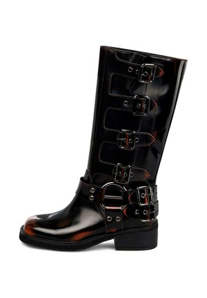 Hohe, glänzende schwarze Lederstiefel mit vier seitlichen Schnallen und einem zusätzlichen doppelten Schnallenriemen um den Knöchel, auf einem niedrigen, gestapelten Absatz.