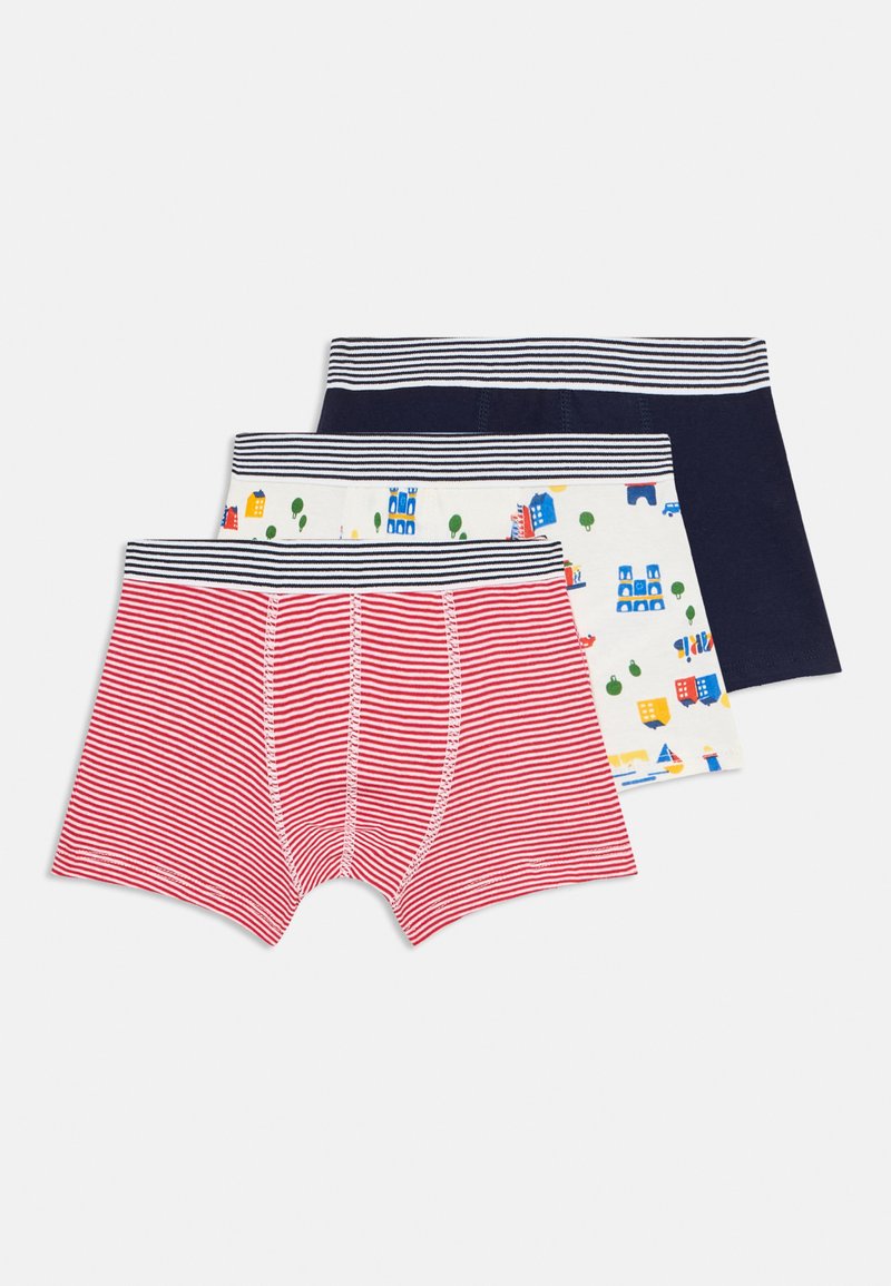 Tre paia di boxer da ragazzo piegati: uno a righe rosse e bianche, uno bianco con edifici e alberi colorati, uno blu navy uniforme, ciascuno con cinturini a righe.